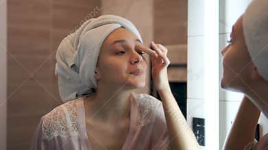 Young woman applies facial Cleaner for skin wash. girl washing face in morning in bathroom. Self Care morning bathroom