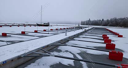 Aerial View of dead frozen harbour docks with boat and ice below. Extreme cold weather.
