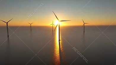 Offshore wind farm in the sea at sunrise or sunset. Aerial view of Windpark with wind turbines, windmills in Netherlands.