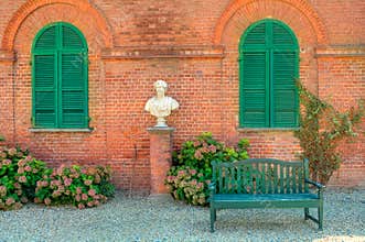 Wooden bench in front of red brick house in Italy.