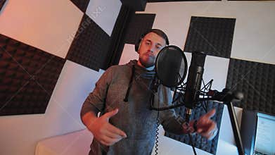 Vocal Recording Session in Sound Studio, An aspiring male vocalist recording music in a soundproof studio with