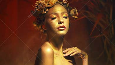 woman goddess. Artistic makeup gold color, skin with shiny sparkling paint