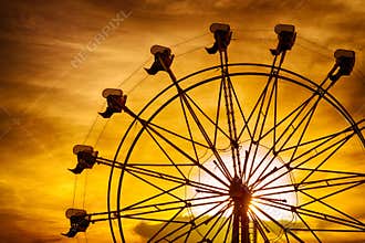 Silhouette of ferris wheel at sunset at county fair