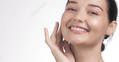 Smiling Young Woman with Radiant Skin Touching Face on White Background