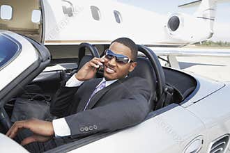 Businessman Using Cell Phone In Convertible