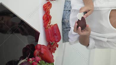 Woman cutting an avocado into two halves with a knife and revealing a vegetable, close-up
