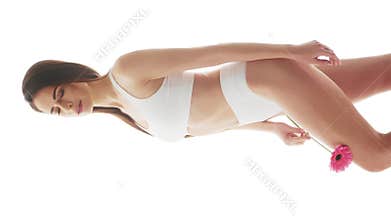Beautiful woman in white underwear over isolated white background. Vertical studio video of healthy young girl in