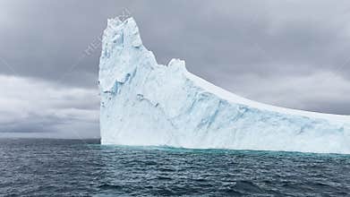 A huge high breakaway glacier drifts in the southern ocean off the coast of Antarctica at sunset, the Antarctic