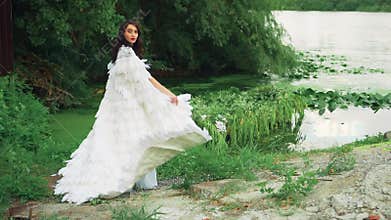 Fantasy woman queen in white dress. Creative clothing, cloak natural feathers