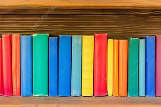 wooden shelf with row of colorful childrens books