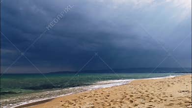 Sunny beach, beautiful turquoise sea, thunderstorm in the background, dark clouds and lightning flashes