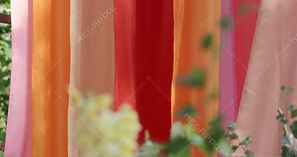 close-up of colorful fabrics in pink, orange and red pastel colors and flowers