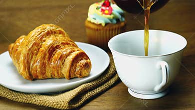 Closeup view pouring black coffee into white ceramic cup.