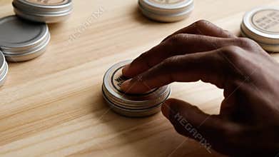 Hand Placing Labels on Cosmetic Containers of Aloe Vera Gel and Rosehip Oil on Wooden Surface Packaging Skin Care