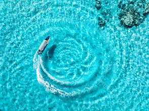 Aerial drone view of the speed boat in clear blue sea in summer