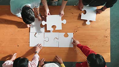 Top down view of business people assemble jigsaw puzzle on table. Convocation.