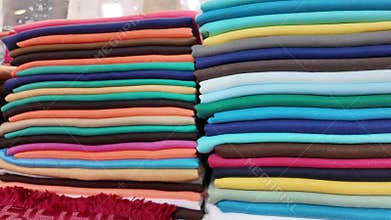Brightly colored fabrics stacked neatly in a shop display