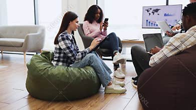 Team members collaborating using digital devices in modern workspace