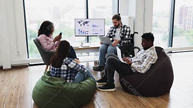 Diverse team excitedly celebrating success in modern office workspace
