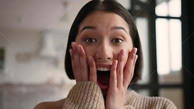 Close up portrait shocked happy Hispanic woman holding face surprised at home Caucasian Latina girl reaction shock