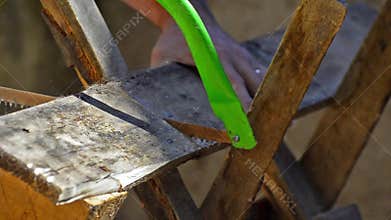 Man Uses Manual Hand Saw tool