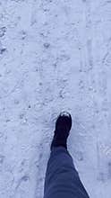 Man walking through the crisp snow in a winter forest