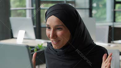 Happy Muslim business woman winning saying wow in office with computer Islamic businesswoman in hijab female girl