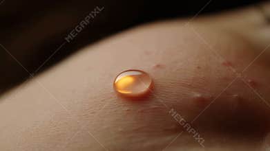Intimate closeup capturing skin imperfections and radiant golden oil on textured epidermis