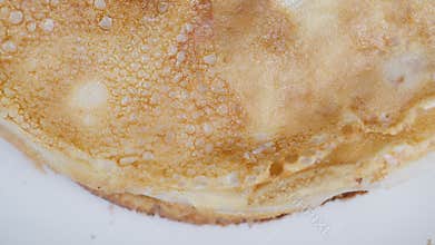 Closeup golden homemade thin pancakes stacked on plate, detailed surface bubbles, crisp edges, warm tones, natural light, minimal