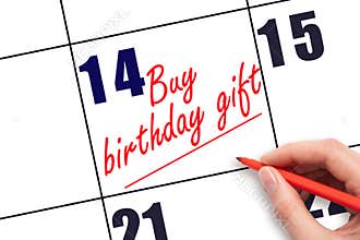 14 th day of the month. Hand writing Buy birthday gift reminder and drawing a line on calendar with red pen on white background