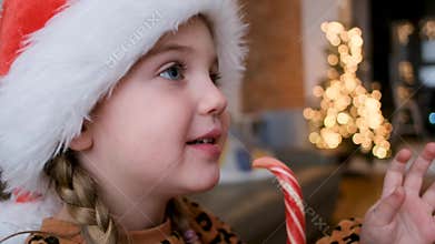 A Festive Child is Happily Enjoying a Candy Cane While at Home During the Holiday Season
