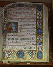 Illuminated choir book with decorated initials, musical notation, and floral