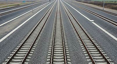 Vast network of parallel railway tracks stretching towards the horizon under a cloudy sky