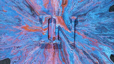 Skilled branding expert exhibits vibrant blue symbols against textured pouring surface in formal setting