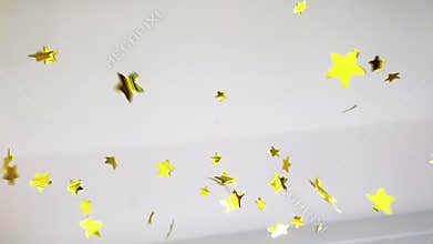 Gold confetti made from stars on white. Bright festive concept