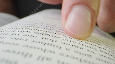 Macro close-up of finger moving through page of music publishing book