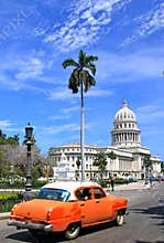 HavanaÂ´s Capitolio with orange vintage car, Cuba