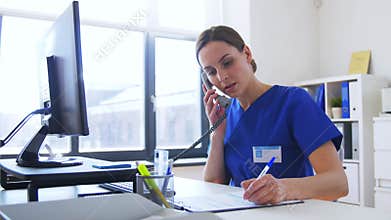 Doctor with computer calling on phone at hospital