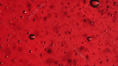 Extreme macro slow motion bubbles in red gel.  Fine bubbles rising In a glass with liquid