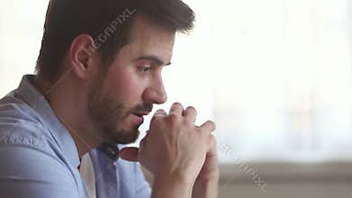 Thoughtful upset millennial man concerned about problem making difficult decision