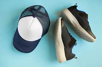 Baseball cap and sneakers on blue background composition
