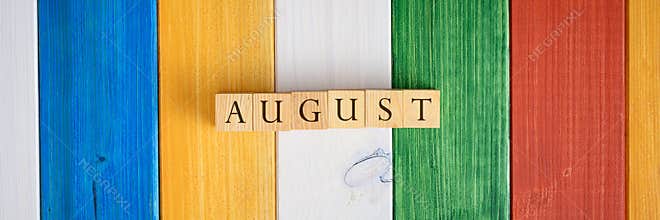 Wide view image of wooden cubes spelling the word August