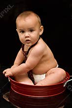 Adorable baby boy wearing tie in red pan