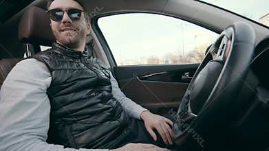 A person does not touch steering wheel while a car is self-parking.