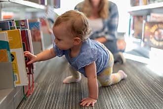 Barrington, IL/USA - 09-23-2019: Toddler girl crawling in the library