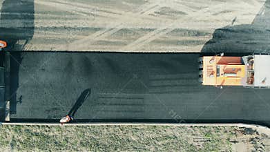 A machine rolls asphalt on a road.