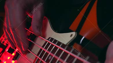 Close up of Hand Playing Modern Bass Guitar