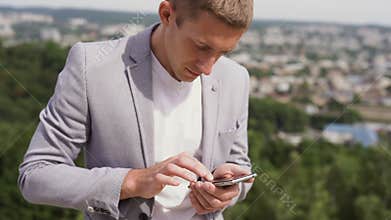 Portrait of a man using mobile phone, holding device, texting, surfing internet, and using app. Man with a coffee and