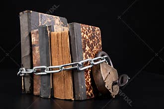 Old books strapping a shiny chain. Forbidden literature locked with a padlock