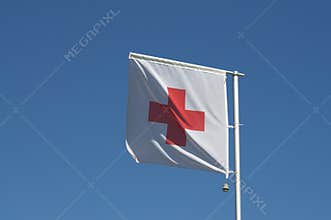 International Red Cross flag against blue sky